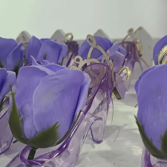 Rosas moradas en un zapato transparente con un lazo.