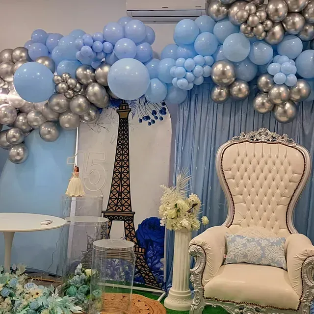 Una habitación con una silla, una mesa y globos.