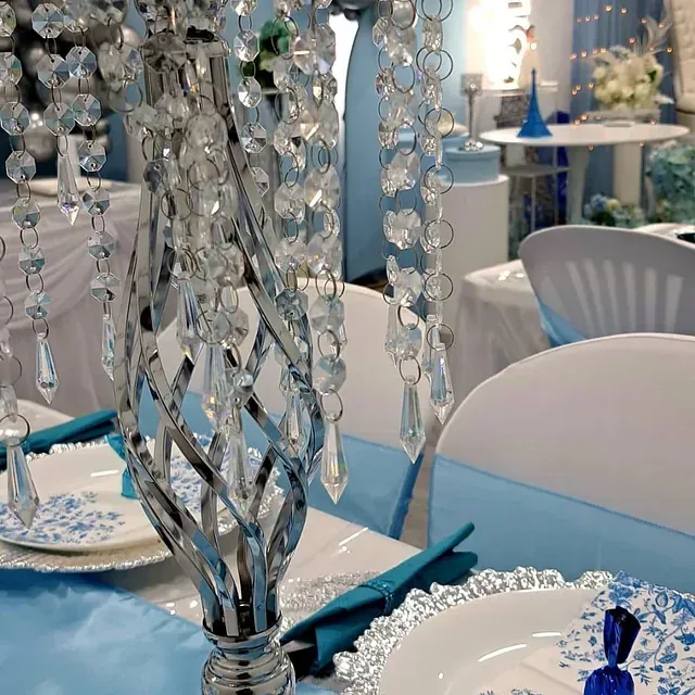 Una mesa con platos y un jarrón con cristales encima.