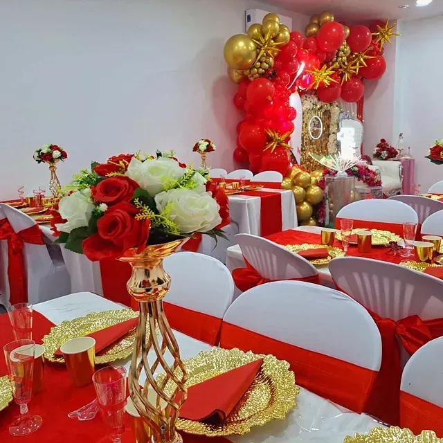 Una habitación llena de mesas y sillas con decoraciones rojas y doradas.