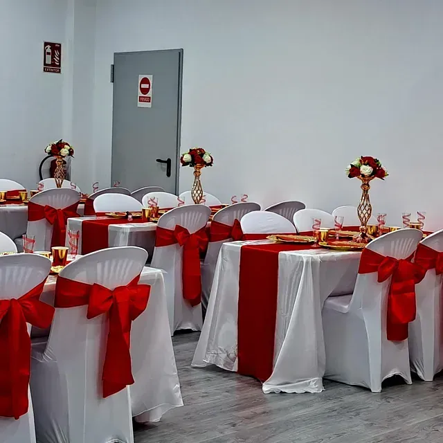 Una habitación con mesas y sillas decoradas en rojo y blanco.