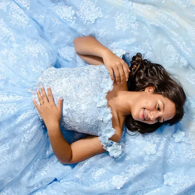 Una mujer con un vestido azul claro está acostada boca arriba.