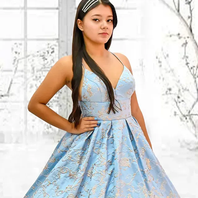Una mujer con un vestido azul claro está parada frente a una ventana.