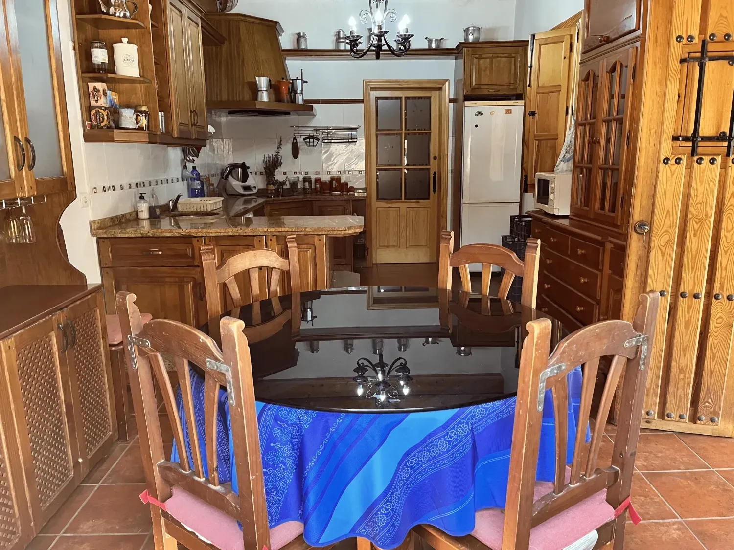 Cocina de madera y comedor con mesa preparada para comer.