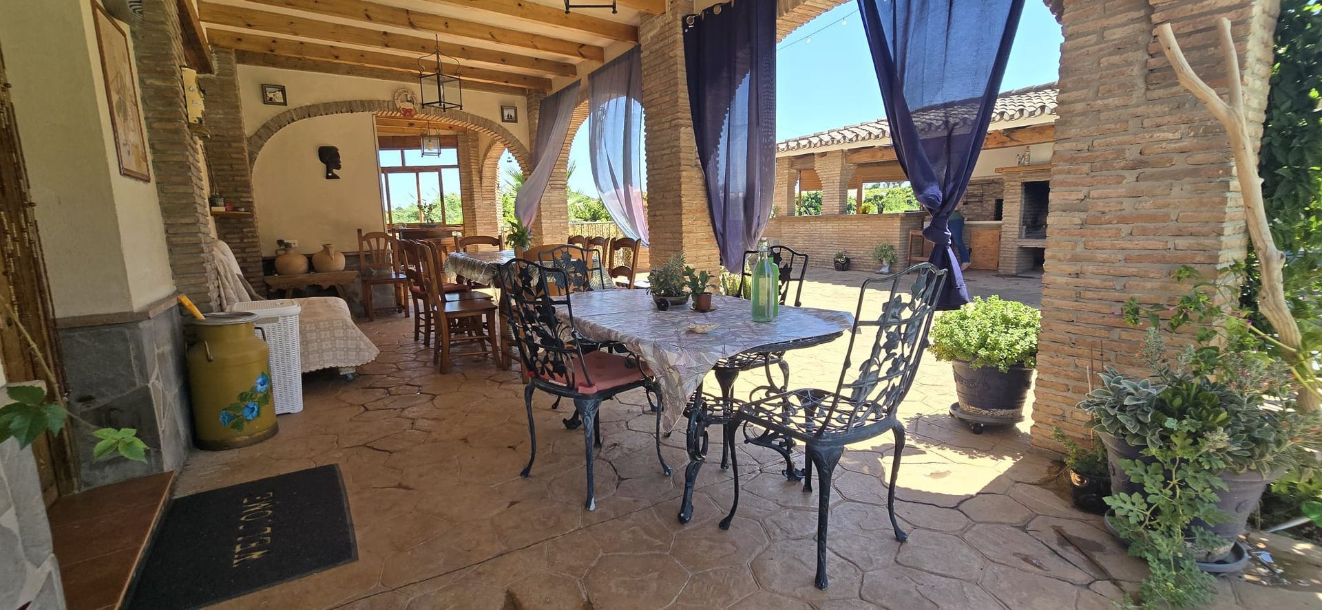 Comedor exterior cubierto con mesas y sillas.