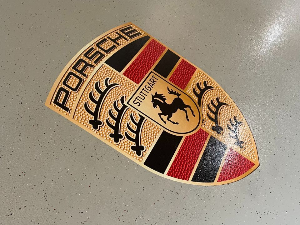 Bodenbeschichtung in Graubraun mit Porsche-Logo in Nahaufnahme, ausgeführt von der Firma Stefanie Fünfstück-Herold