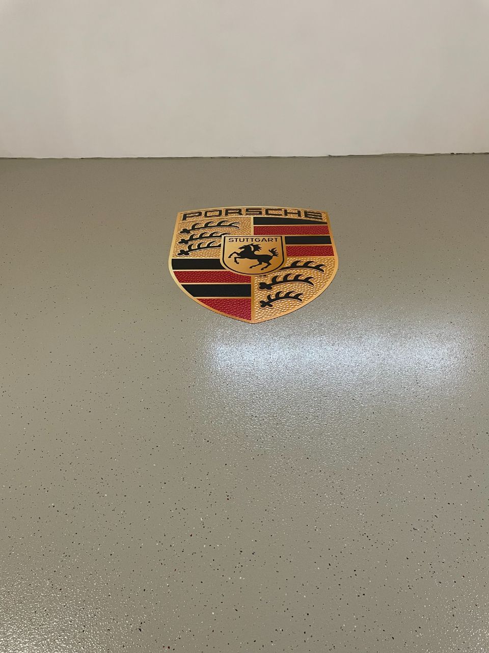 Bodenbeschichtung in Graubraun mit Porsche-Logo, ausgeführt von der Firma Stefanie Fünfstück-Herold