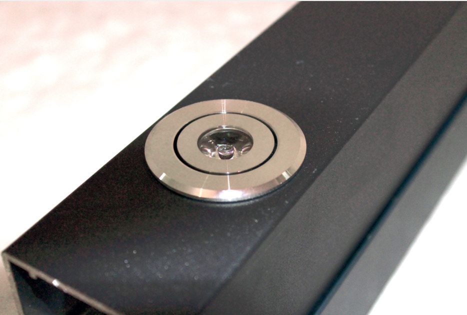 Schwarzes, rechteckiges Objekt mit einem silbernen, runden Knopf.