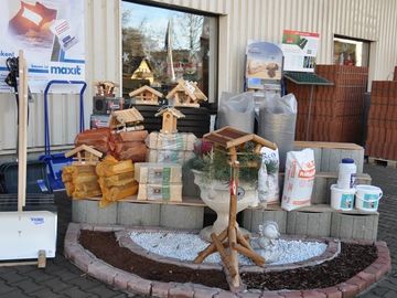 Festlich dekorierte Schaufensterdekoration mit kleiner Krippe und verpackten Geschenkkartons.
