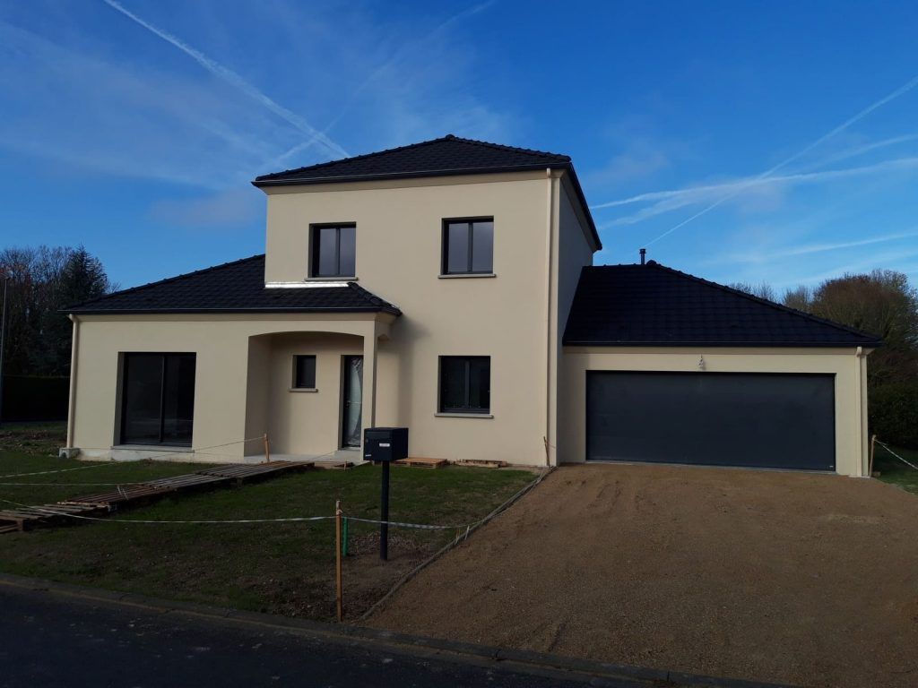 Maison à étage couleur crème et toit en tuiles foncées