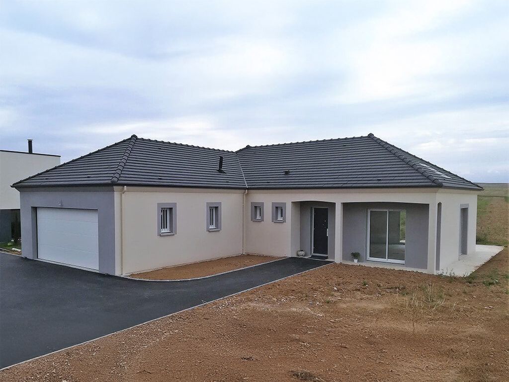 Maison individuelle neuve en L avec murs clairs et certaines surfaces en gris