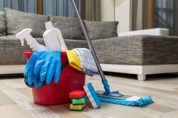 Detergenti, spugne, guanti, mop e secchio per pulizia appartamento