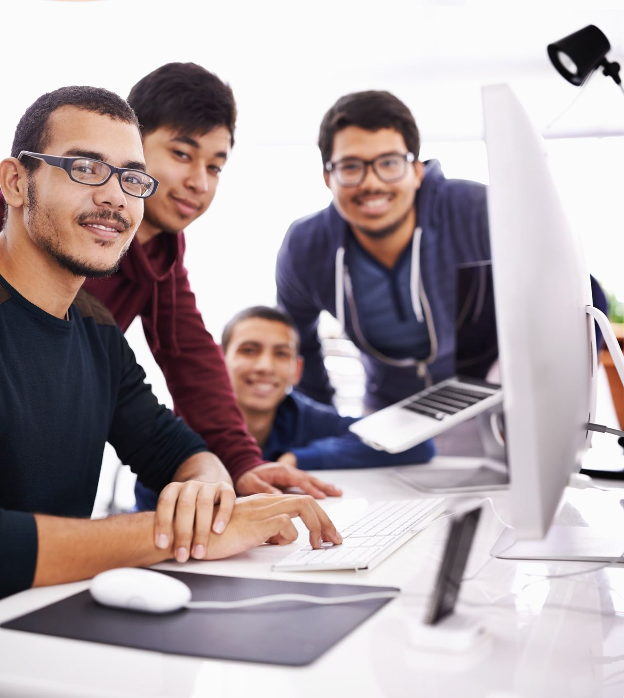 Un grupo de jóvenes están trabajando juntos en una computadora.