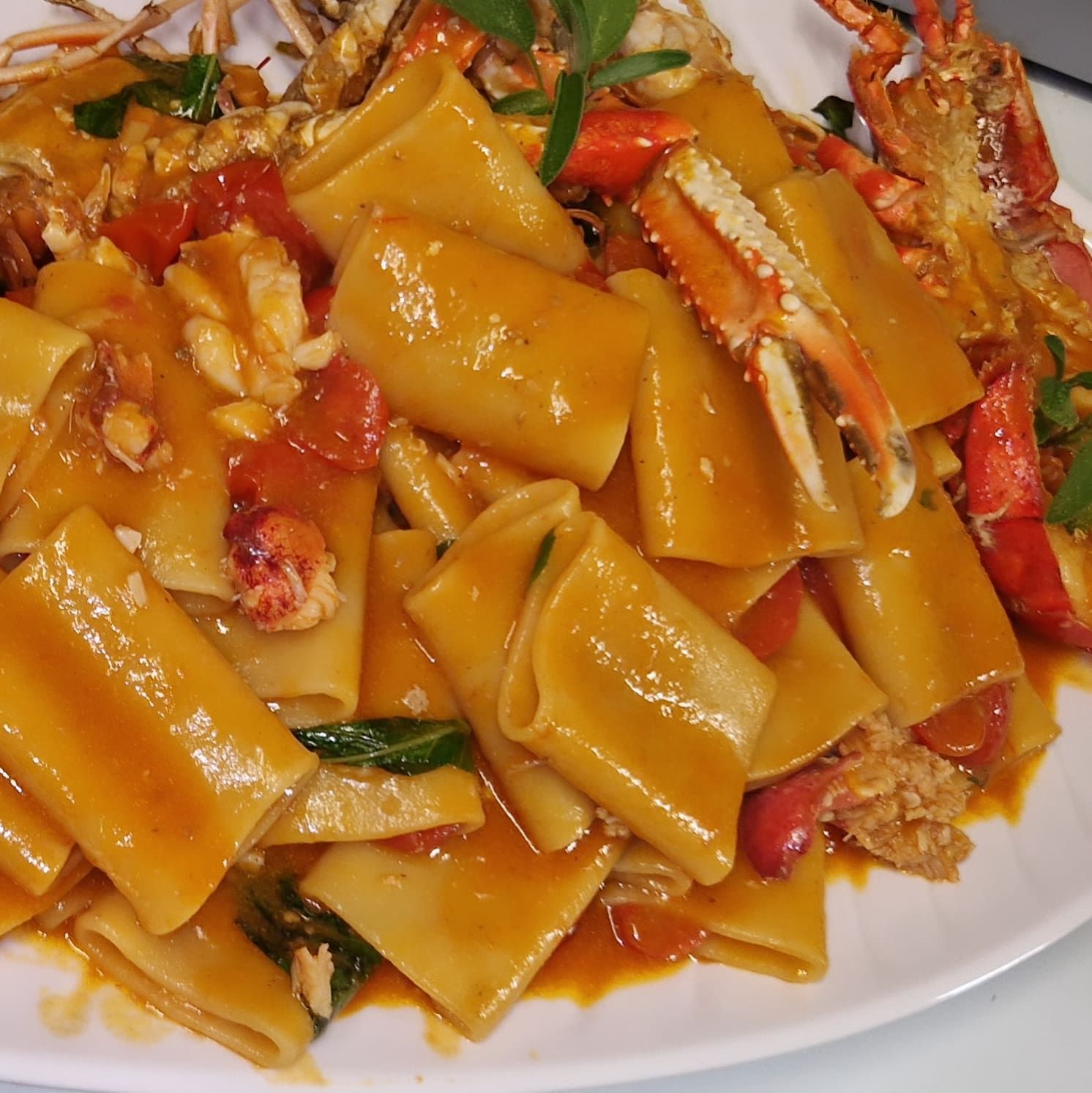 Carré d'agneau avec aubergines rôties et glaçage balsamique sur une assiette blanche.