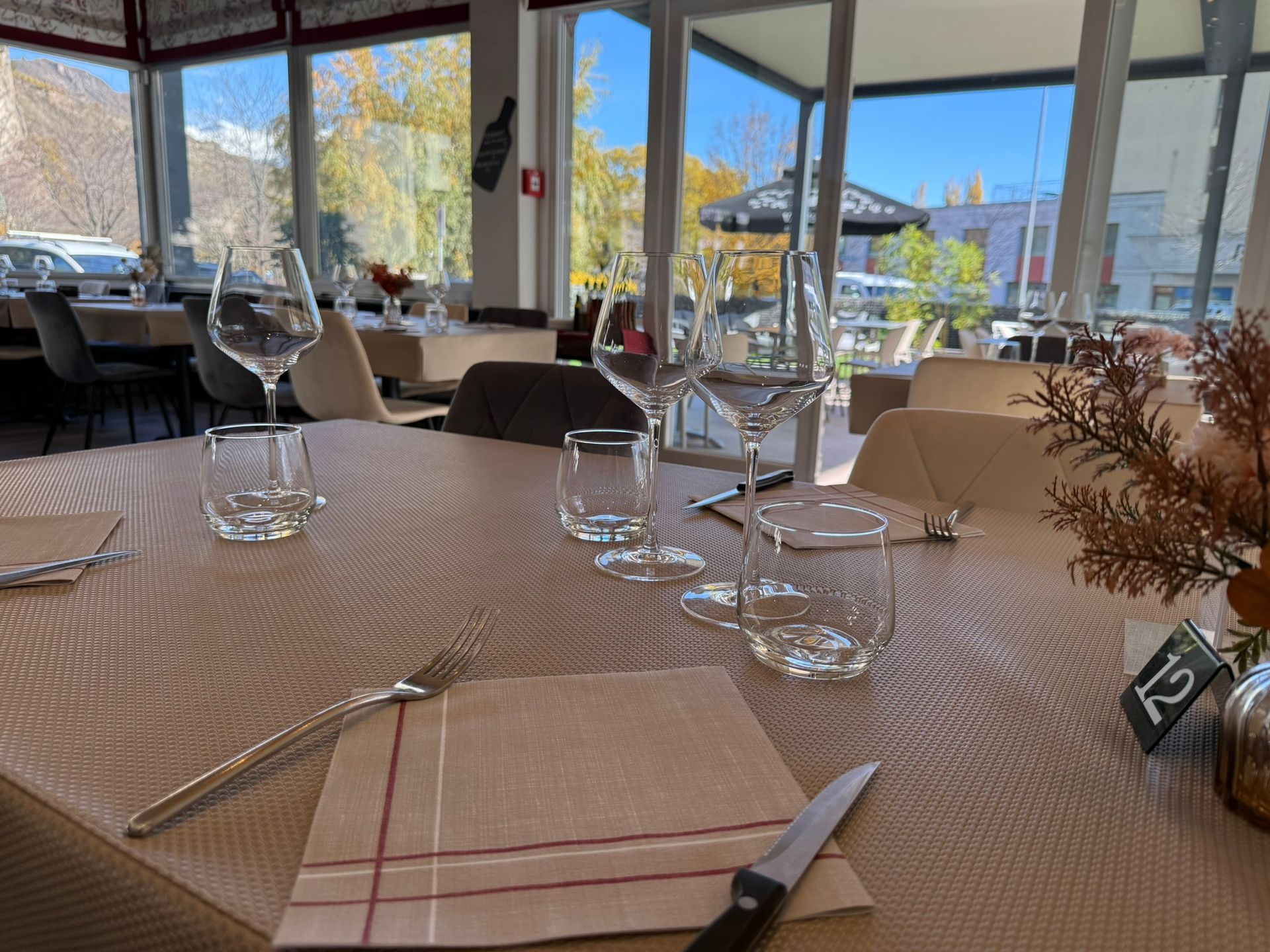 Vue aérienne d'une table en bois dressée avec des assiettes de nourriture, du pain et une boisson.
