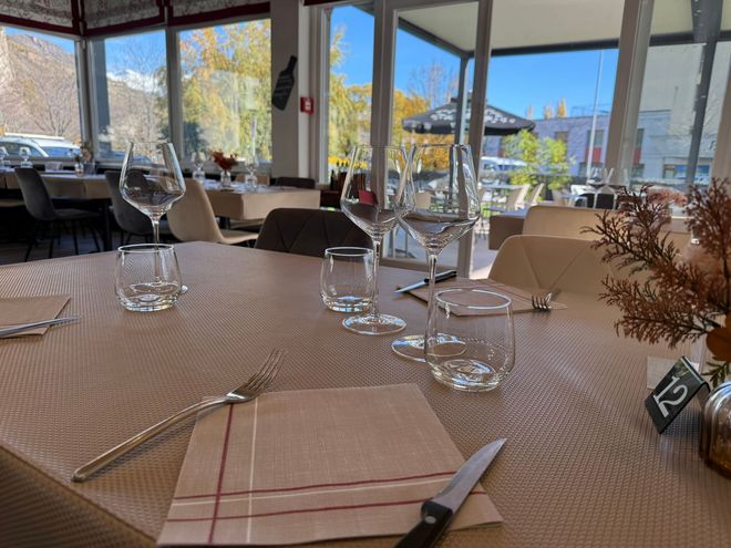 Vue aérienne d'une table en bois dressée avec des assiettes de nourriture, du pain et une boisson.