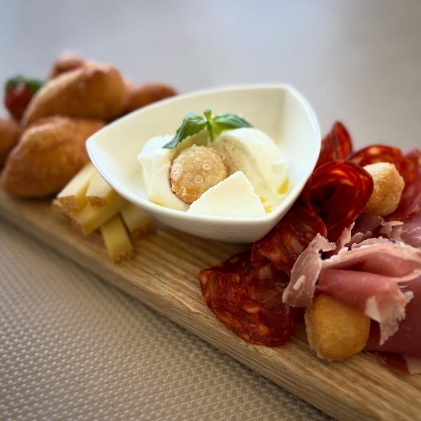 Salle à manger du restaurant avec tables dressées pour les clients, baignée de lumière naturelle grâce à de grandes fenêtres.
