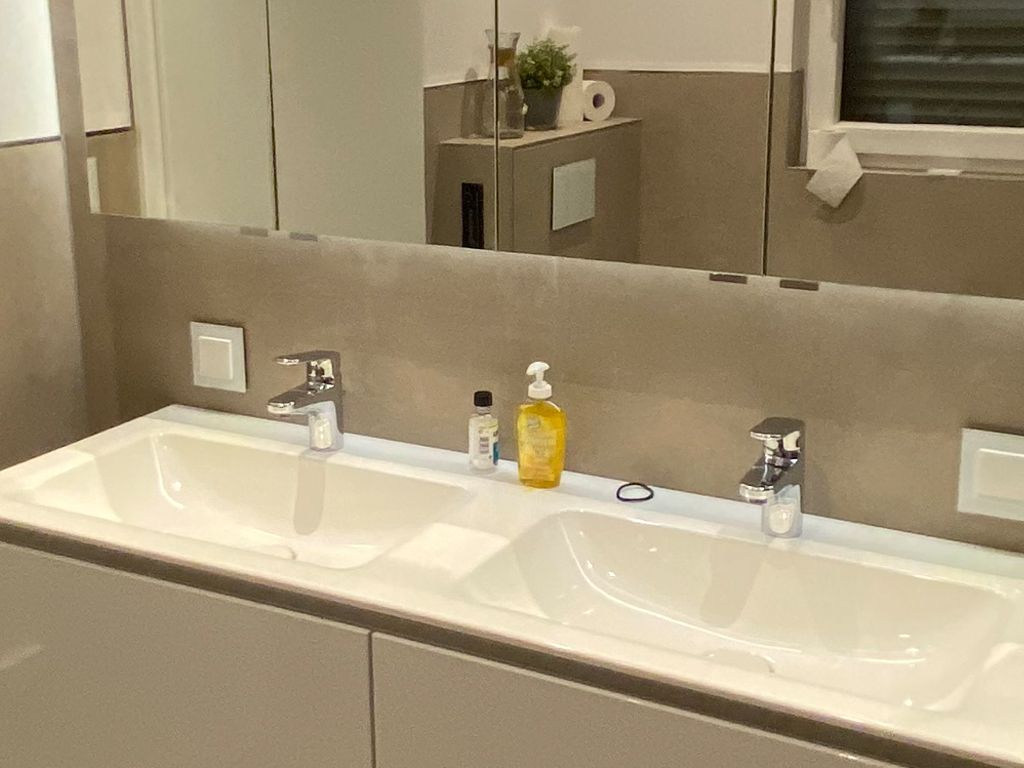 Ein Badezimmer mit zwei Waschbecken und einem Spiegel