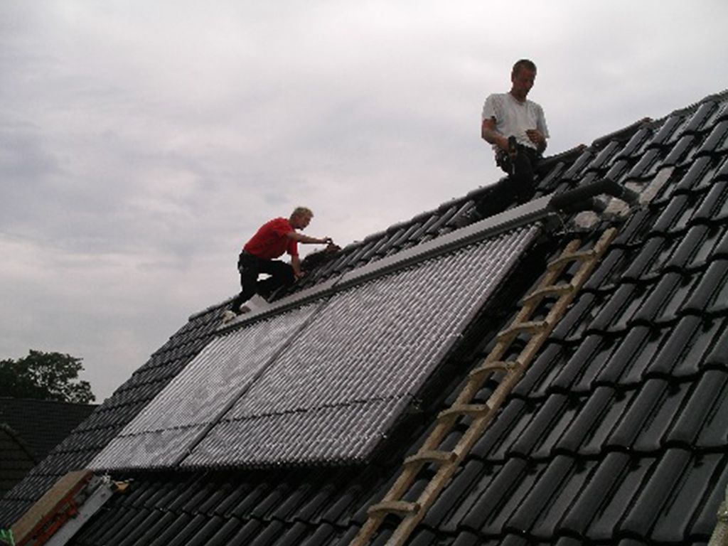 Zwei Männer installieren Solarmodule auf einem Dach
