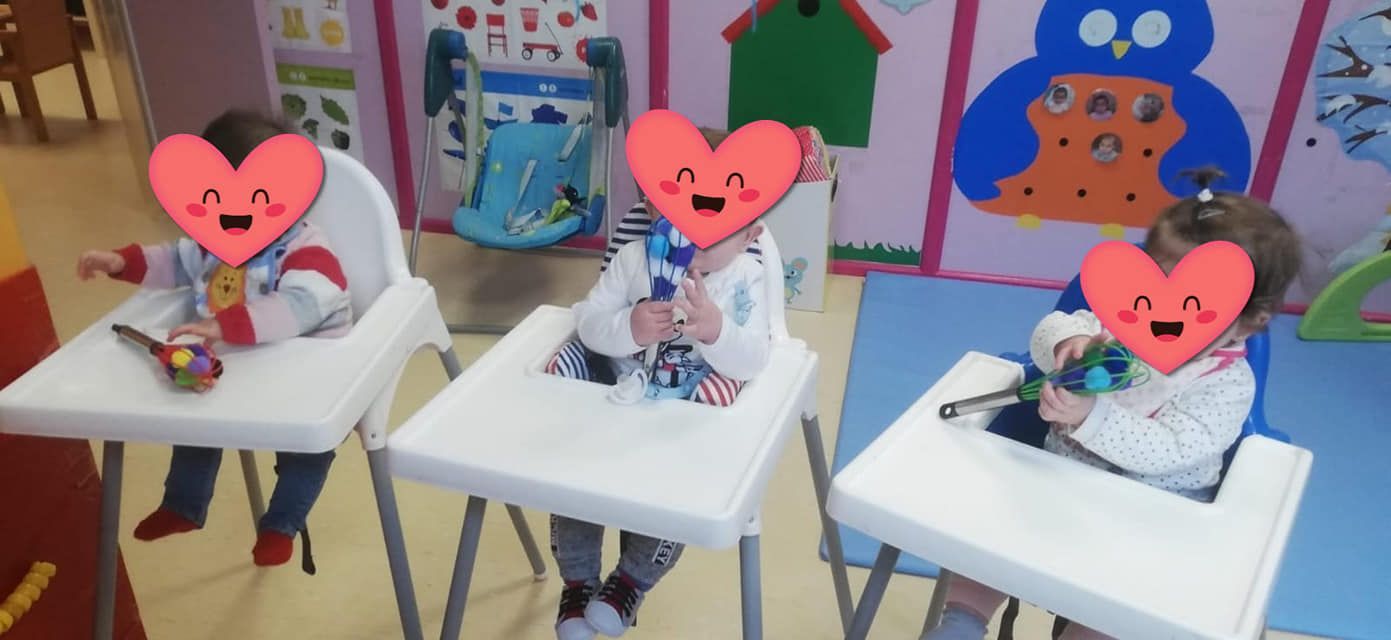 Un grupo de niños están sentados en sillas altas con corazones en sus caras.