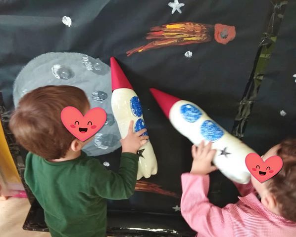 Un niño y una niña están jugando con cohetes de peluche.