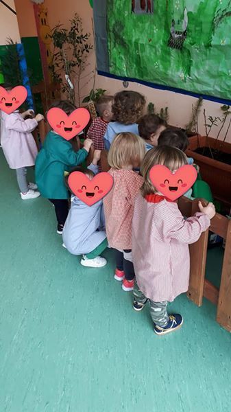 Un grupo de niños están parados en fila en una habitación con corazones en sus caras.