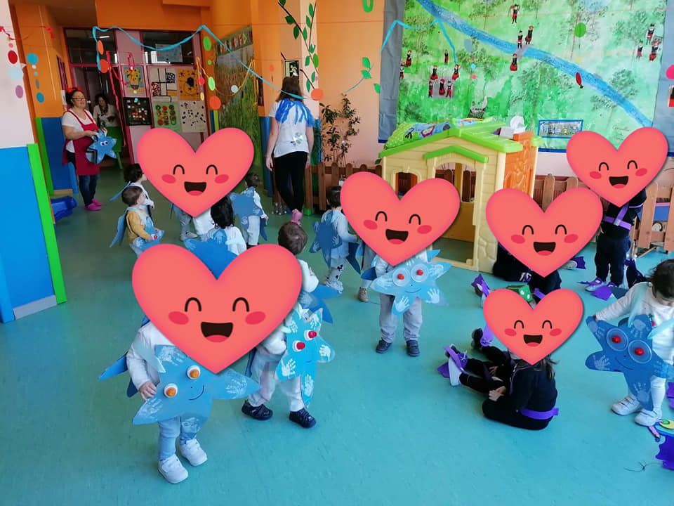 Un grupo de niños están de pie en una habitación con corazones en sus caras.