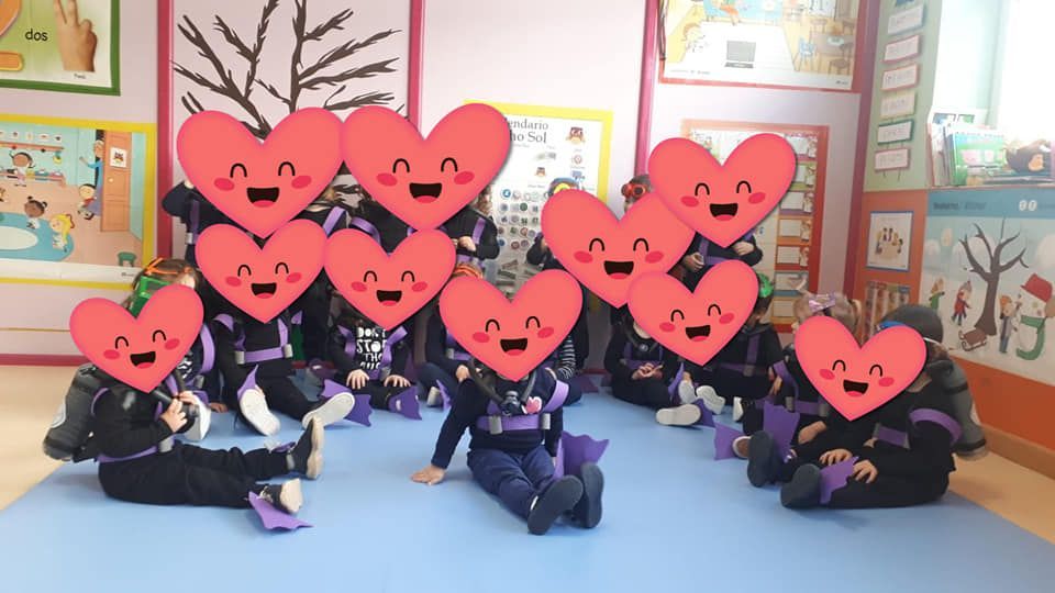 Un grupo de niños posan para una foto con corazones en sus caras.