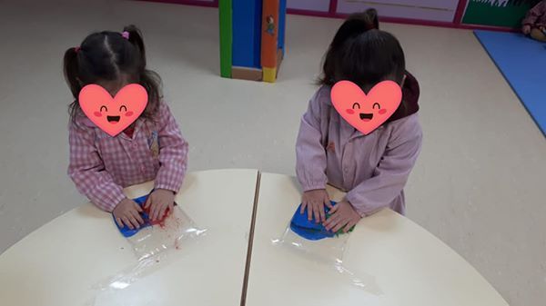 Dos niñas con corazones en sus caras están sentadas en una mesa.