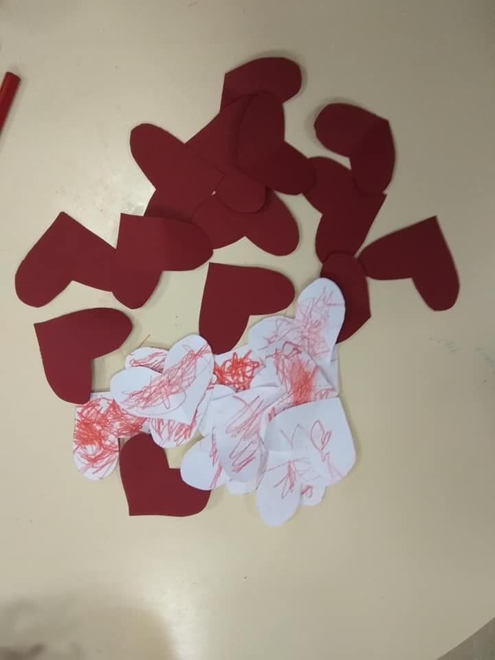 Un montón de corazones rojos y blancos sobre una mesa.