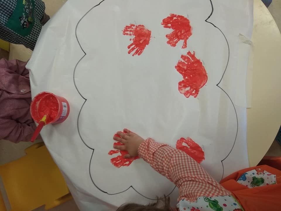 Un niño está pintando una nube con pintura roja.