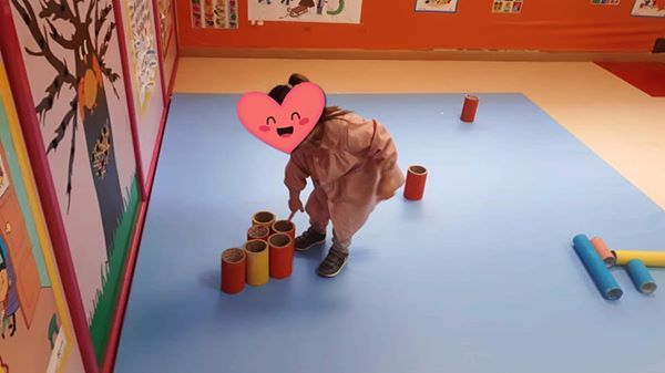 Una niña con un corazón en la cabeza está jugando con rollos de papel higiénico.