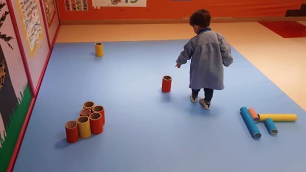 Una niña camina sobre una alfombra azul en una habitación.