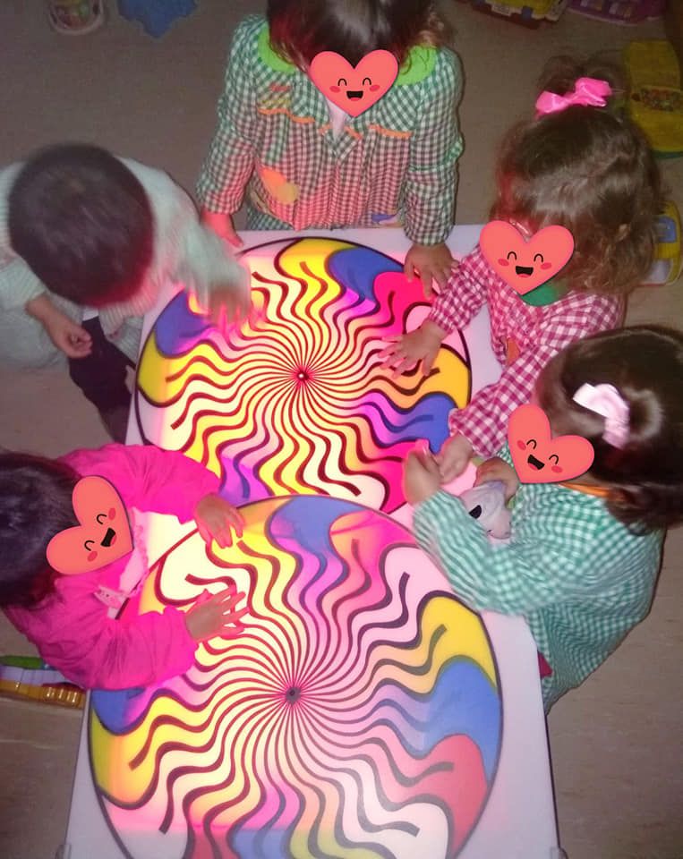 Un grupo de niños está jugando con una ilusión óptica colorida.