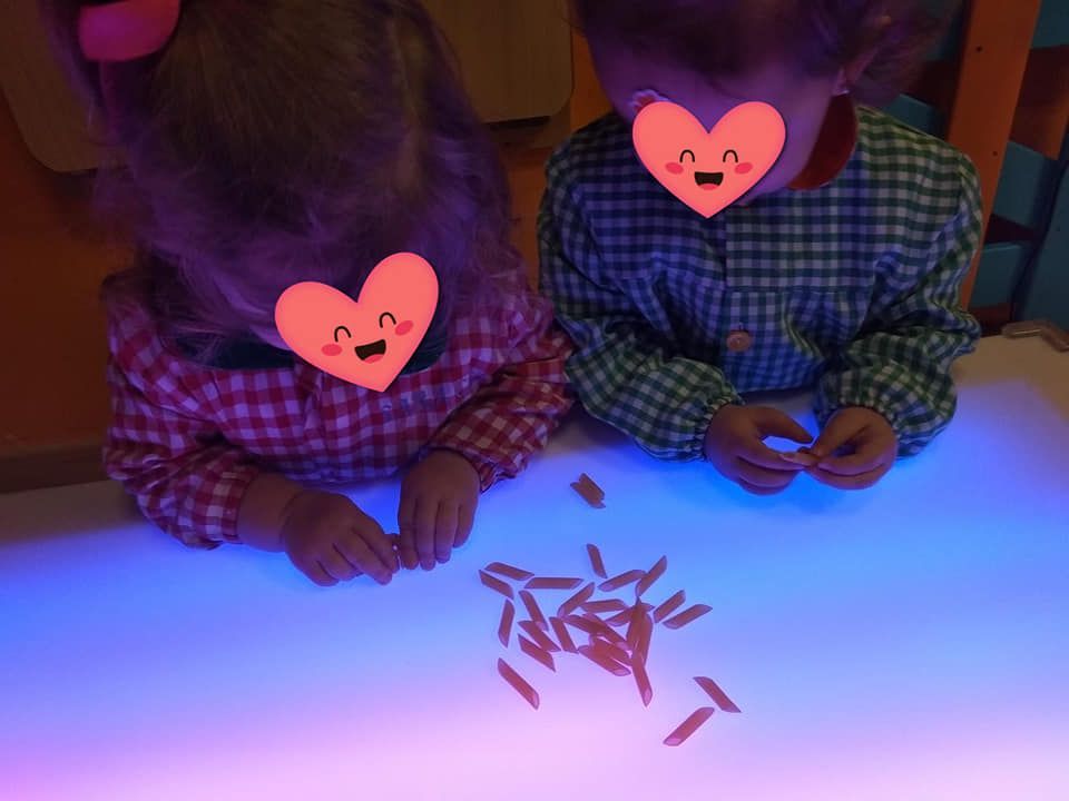 Un niño y una niña están sentados en una mesa con un corazón en sus caras.