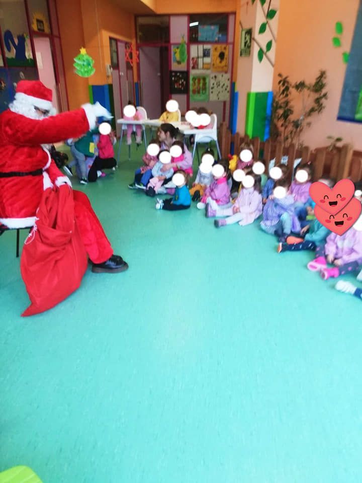 Un grupo de niños están sentados en una habitación con Papá Noel.