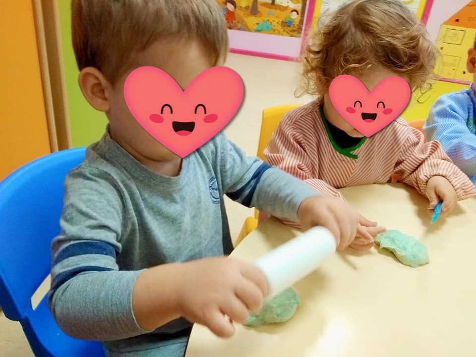 Un niño con un corazón en la cara está jugando con plastilina.