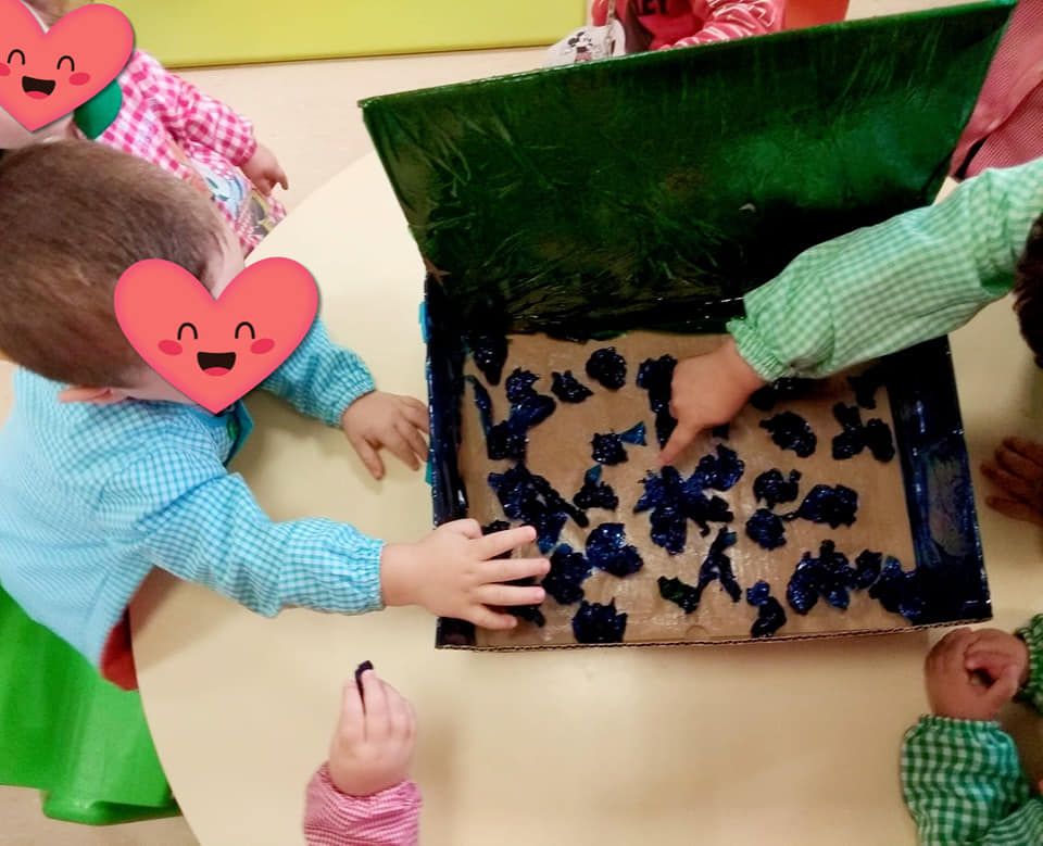 Un grupo de niños está jugando con una caja de arándanos.