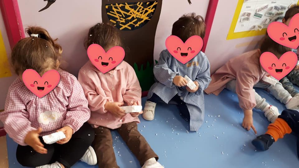 Un grupo de niños están sentados en el suelo con corazones en sus caras.