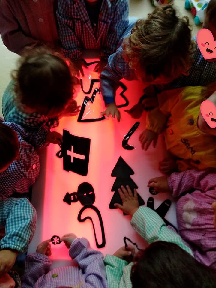 Un grupo de niños juega con juguetes que brillan en la oscuridad.