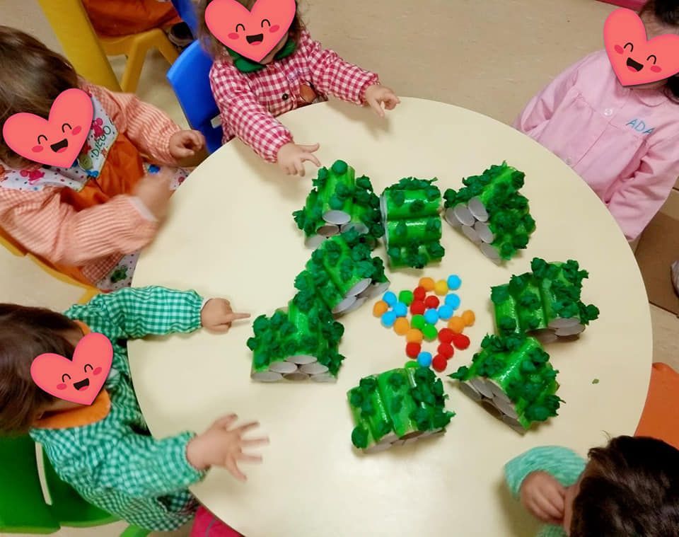 Un grupo de niños con corazones en sus caras se sientan alrededor de una mesa.