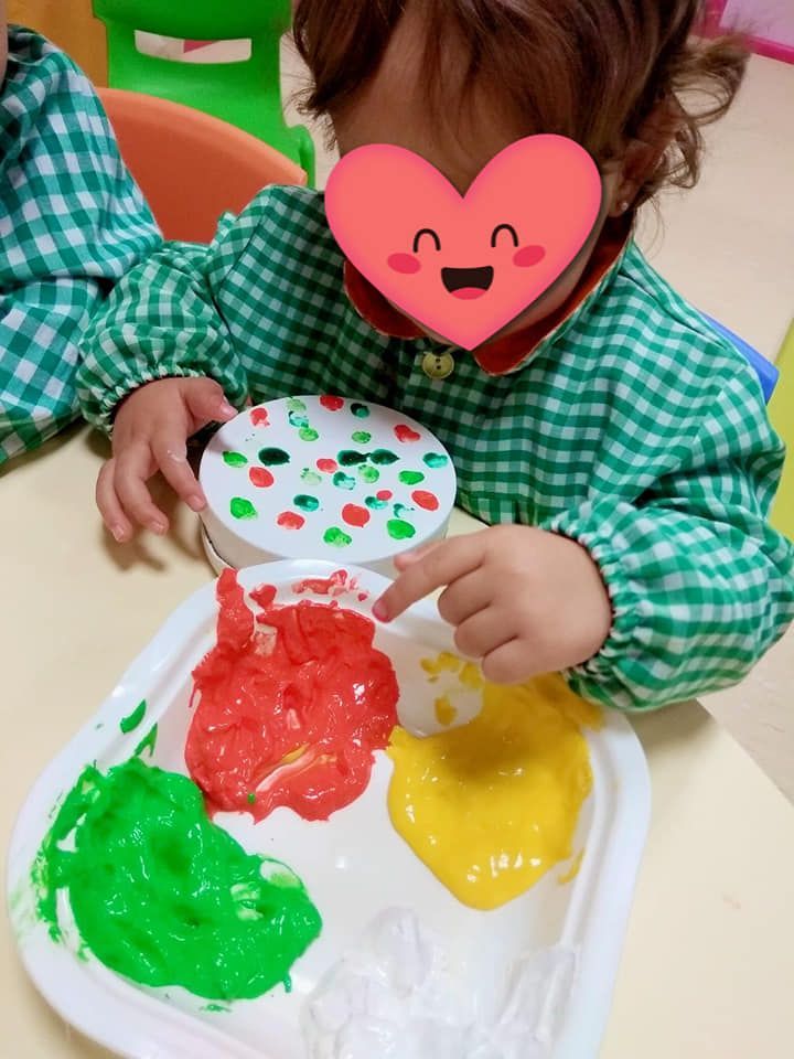 Una niña con un corazón en la cara está jugando con pintura.