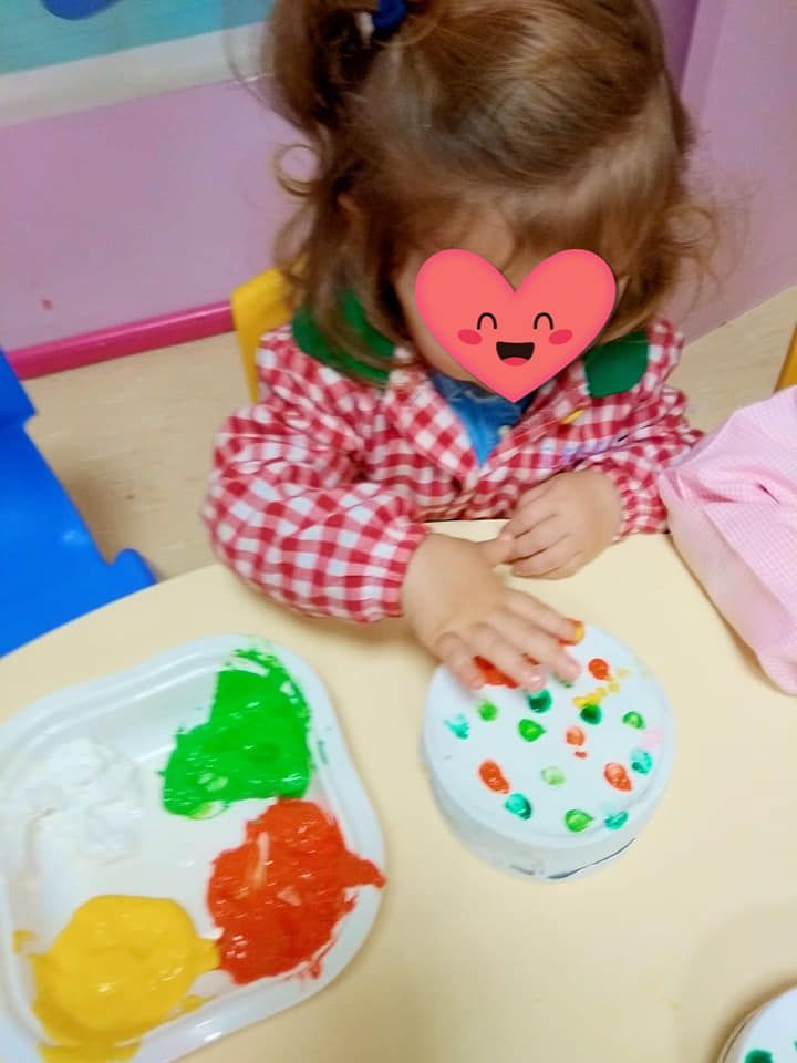 Una niña con un corazón en la cara está jugando con pintura.