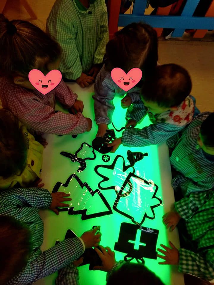 Un grupo de niños juega con juguetes que brillan en la oscuridad.