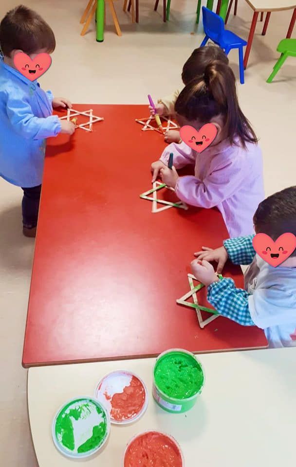 Un grupo de niños están sentados en una mesa jugando con masa.