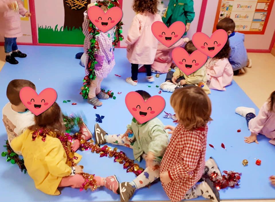 Un grupo de niños están sentados en el suelo con corazones en sus caras.