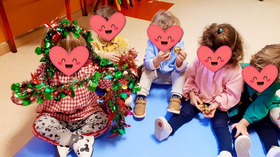 Un grupo de niños con corazones en sus caras están sentados en el suelo.