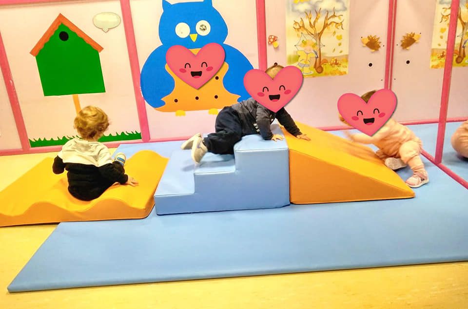 Un grupo de bebés está jugando en una sala de juegos.