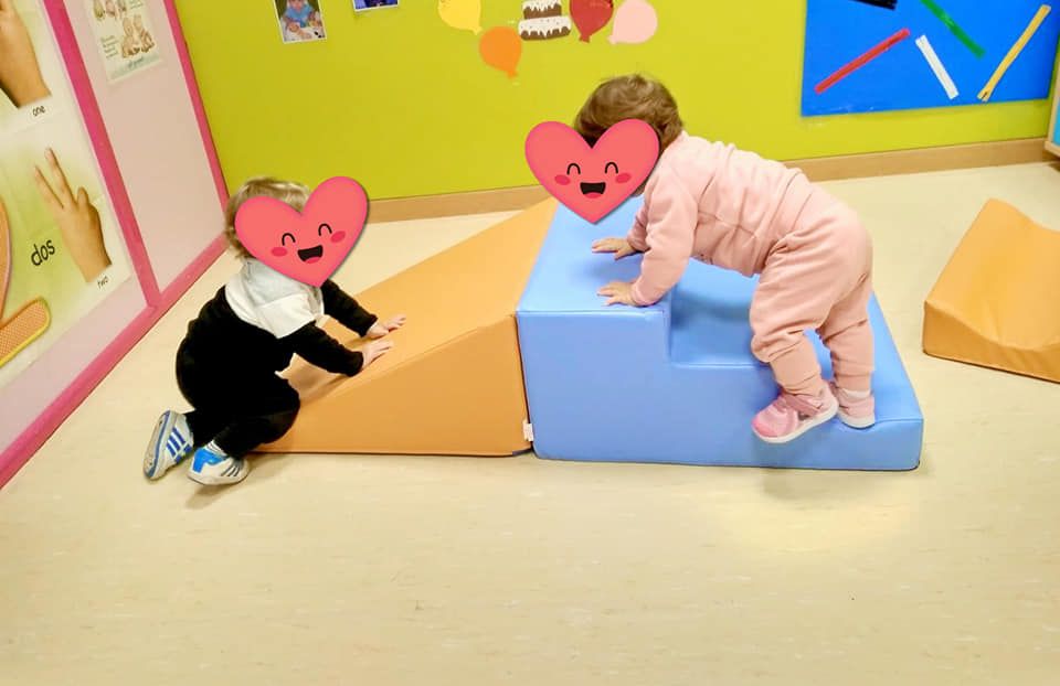 Dos bebés con corazones en sus caras están jugando en una habitación.