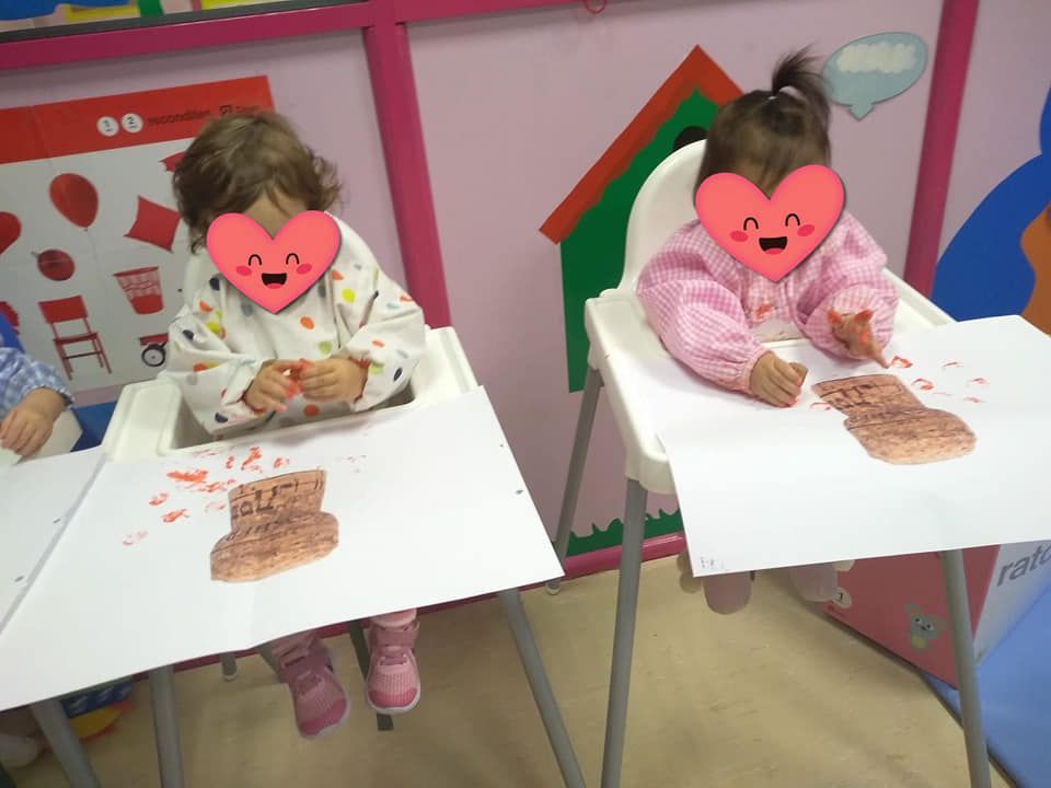 Dos niñas sentadas en sillas altas con corazones en sus caras